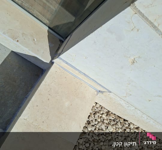 פינת קיר עם אריחים ואבנים קטנות